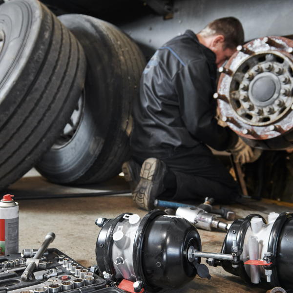 Professional technician works on big rig's brakes